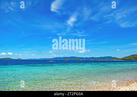 Ein Boot in klarem Meerwasser vor der Küste einer tropischen Insel in der Coron Bay. Provinz Palawan, Busuanga, Philippinen Stockfoto