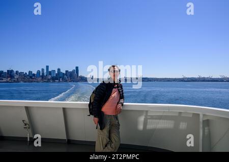 Touristen posieren für Telefone auf der Fähre in Elliott Bay. Skyline von Seattle und Hafen von Seattle im Hintergrund. Seattle. Bundesstaat Washington. Stockfoto