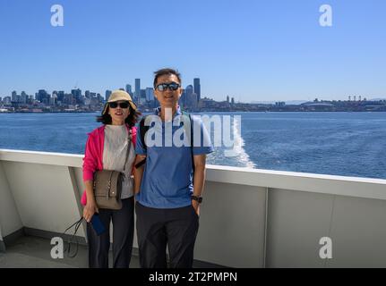 Touristen posieren für Telefone auf der Fähre in Elliott Bay. Die Skyline von Seattle im Hintergrund. Seattle. Bundesstaat Washington. Stockfoto