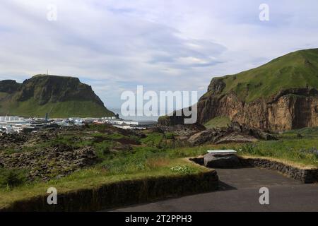 Blick auf das Dorf Heimaey auf der Insel Heimaey, mit dem Lavastrom des Vulkans Eldfell-Vestmannaeyjar im Vordergrund Stockfoto