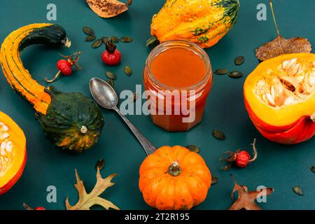 Herbstliche süße Kürbismarmelade in einem Glasgefäß und frische Kürbisse. Kürbiskonfiture. Stockfoto