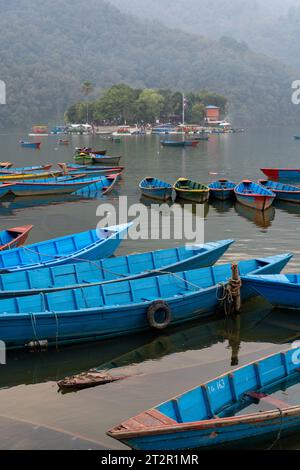 Ein Haufen bunter Holzboote auf dem Fewa Lake in Pokhara, Nepal. Stockfoto