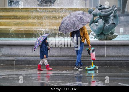 London, Vereinigtes Königreich 21. Oktober 2023. Menschen, die unter Regenschirmen auf dem Trafalgar Square unter Regenschauer schützen, während Storm Babet weiterhin die britischen .Credit amer ghazzal/Alamy Live News trifft Stockfoto