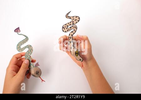 Eine Schlange oder ein Drache aus recyceltem Papier, Heimwerkerarbeit, Tutorial, pädagogische Kunst und Handwerk für Kinder, Stockfoto