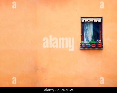 Fenster auf orangefarbenem Hintergrund aus Lehm, Rom, Italien Stockfoto