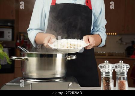 Ein Teller voller gekochter Klöße in den Händen der Frau. Stockfoto