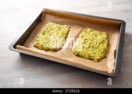 Teig Zucchini und Haferflocken als Basis für vegane Low Carb Pizza oder Gemüsekuchen auf einem Tablett mit Backpapier, Kopierraum, ausgewähltem Fokus, schmal d Stockfoto