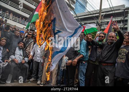 Pro-palästinensische Demonstranten sahen, wie sie während der Demonstration vor der israelischen Botschaft in Bangkok eine israelische Nationalflagge verbrannten. Pro-palästinensische Demonstranten versammelten sich vor der israelischen Botschaft in Bangkok, um ihre Unterstützung für die Palästinenser im israelisch-Hamas-Konflikt in Gaza zum Ausdruck zu bringen. (Foto: Peerapon Boonyakiat / SOPA Images/SIPA USA) Stockfoto