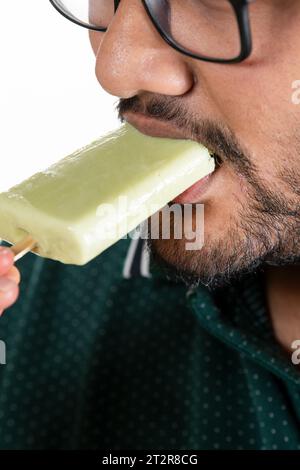 Nahaufnahme Porträt eines asiatischen Mannes, der Eis beißt, isoliert über weißem Hintergrund Stockfoto