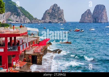 CAPRI, ITALIEN - 22. SEPTEMBER 2023: Ausflugsboote bringen Touristen zu den Faraglioni Rocks. Die Insel Capri ist berühmt für ihre zerklüftete Landschaft. Im Sommer seine Dramati Stockfoto