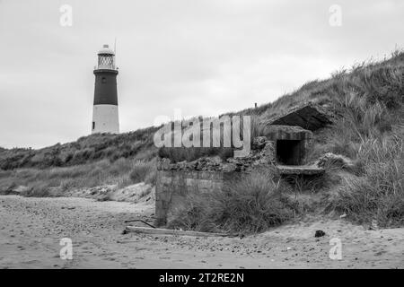 Der viktorianische Leuchtturm und die Waffenverstellung aus dem 2. Weltkrieg am Ende des Werks Sporn Head im East Riding of Yorkshire, Großbritannien Stockfoto