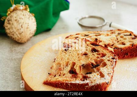 Panettone auf Holzbrett geschnitten, traditioneller italienischer Weihnachtskuchen Stockfoto