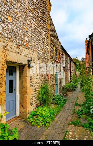 Eine Reihe traditioneller „Volksmund“ Architekturhütten aus Feuerstein, Kieselsteinen und Ziegelsteinen in Cley Next the Sea, North Norfolk, England, Großbritannien Stockfoto