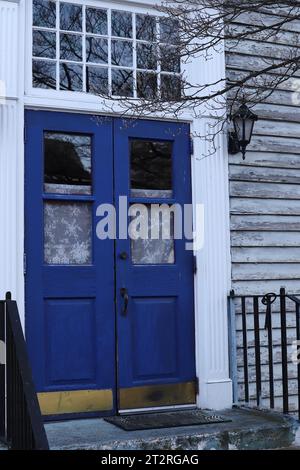 Blaue Doppeltüren und weiße Spitzenvorhänge Stockfoto