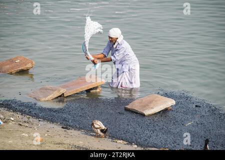 Mann wäscht Kleidung am Ganges Fluss in Varanasi Stockfoto