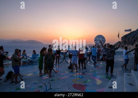 IOS, Griechenland - 11. September 2023 : Touristen, die in einer Lounge-Bar einen Drink trinken und die herrliche Aussicht und den wunderbaren Sonnenuntergang in iOS kykladen Griechenland genießen Stockfoto