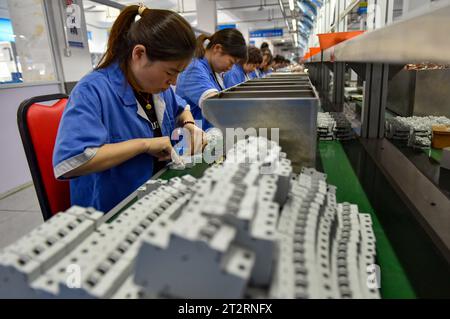 Fuyang, China. Oktober 2023. Frauen mit blauen Overalls arbeiten an der Montagelinie einer Fabrik, die elektrische Geräte herstellt. Das chinesische Bruttoinlandsprodukt wuchs im dritten Quartal um 4,9 Prozent gegenüber dem Vorjahr, nachdem es im zweiten Quartal um 6,3 Prozent gestiegen war und trotz des Abwärtsdrucks eine stetige Erholung verzeichnete, sagte das nationale Statistikbüro am Mittwoch. In den ersten drei Quartalen wuchs Chinas BIP um 5,2 Prozent auf 91,3 Billionen Yuan (12,5 Billionen Dollar) nach einem Wachstum von 5,5 Prozent in der ersten Jahreshälfte. Quelle: SOPA Images Limited/Alamy Live News Stockfoto