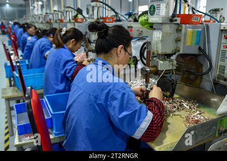Frauen mit blauen Overalls arbeiten an der Montagelinie einer Fabrik, die elektrische Geräte herstellt. Das chinesische Bruttoinlandsprodukt wuchs im dritten Quartal um 4,9 Prozent gegenüber dem Vorjahr, nachdem es im zweiten Quartal um 6,3 Prozent gestiegen war und trotz des Abwärtsdrucks eine stetige Erholung verzeichnete, sagte das nationale Statistikbüro am Mittwoch. In den ersten drei Quartalen wuchs Chinas BIP um 5,2 Prozent auf 91,3 Billionen Yuan (12,5 Billionen Dollar) nach einem Wachstum von 5,5 Prozent in der ersten Jahreshälfte. (Foto: Sheldon Cooper/SOPA Images/SIPA USA) Stockfoto