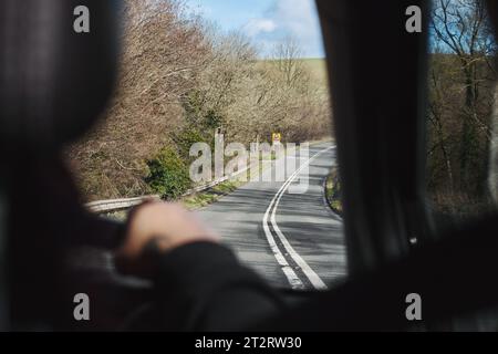 Blickwinkel des Fondpassagiers aus dem Innenraum des Fahrzeugs, Blick aus dem Fenster auf einer Landstraße - Geschwindigkeit auf einspuriger Fahrbahn, Fahrtkonzept Stockfoto