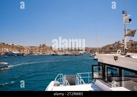 Vittoriosa, Malta - 17. Juni 2023: Hafen von Vittoriosa mit Yachten und Booten und der Kuppel der Kathedrale im Hintergrund, von Bord der Fähre genommen Stockfoto