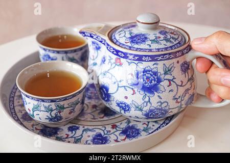 Zwei Tassen heißer chinesischer Oolong-Tee mit Teekanne auf dem Tisch Stockfoto