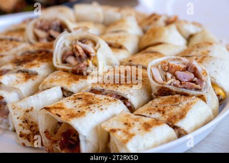 Shawarma-Stücke auf Holztisch mit Dips und auf weißem Teller angeordnet Stockfoto