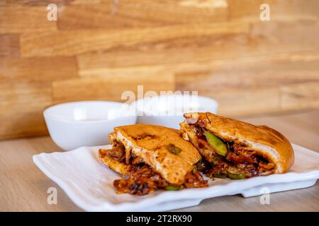 Italienische Shawarma-Stücke voller Paprika und BBQ-Saucen mit Huhn auf Holztisch mit Dips Stockfoto