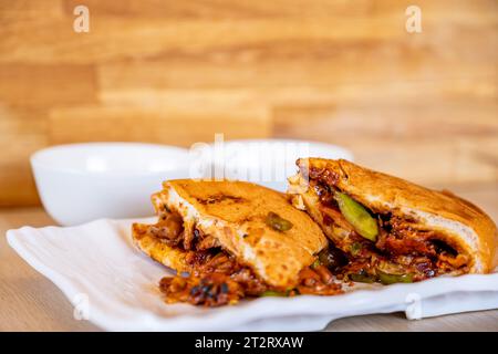 Italienische Shawarma-Stücke voller Paprika und BBQ-Saucen mit Huhn auf Holztisch mit Dips Stockfoto
