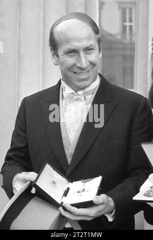 Aktenfoto vom 12.02.1974 von Manchester United und dem englischen Fußballspieler Bobby Charlton mit seinem CBE, den er von der Queen Mother im Buckingham Palace erhalten hatte. Sir Bobby Charlton ist im Alter von 86 Jahren gestorben, teilte seine Familie mit. Ausgabedatum: Samstag, 21. Oktober 2023. Stockfoto