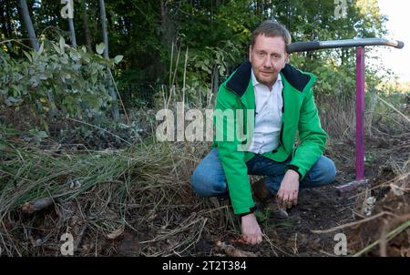 21. Oktober 2023, Sachsen, Königshain: Premierminister Michael Kretschmer nimmt an der Pflanzkampagne „Oberlausitzer Zukunftswald“ in Königshain Teil. Die Wiederaufforstung des 1,2 ha großen, geschädigten Gemeindegebiets ist das Ergebnis einer Crowgründungsaktion. Mit der Anpflanzung von über 3.000 Setzlingen verschiedener Baumarten durch Einwohner der Oberlausitz soll auf einem ehemaligen Rindenkäfer-beschädigten Gebiet ein klimaverträglicher, artenreicher Mischwald entstehen. Foto: Matthias Rietschel/dpa Stockfoto