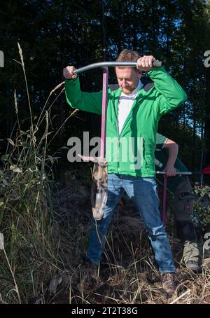 21. Oktober 2023, Sachsen, Königshain: Premierminister Michael Kretschmer nimmt an der Pflanzkampagne „Oberlausitzer Zukunftswald“ in Königshain Teil. Die Wiederaufforstung des 1,2 ha großen, geschädigten Gemeindegebiets ist das Ergebnis einer Crowgründungsaktion. Mit der Anpflanzung von über 3.000 Setzlingen verschiedener Baumarten durch Einwohner der Oberlausitz soll auf einem ehemaligen Rindenkäfer-beschädigten Gebiet ein klimaverträglicher, artenreicher Mischwald entstehen. Foto: Matthias Rietschel/dpa Stockfoto