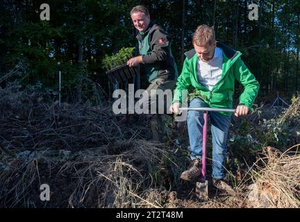 21. Oktober 2023, Sachsen, Königshain: Premierminister Michael Kretschmer (r) nimmt an der Pflanzkampagne „Oberlausitzer Zukunftswald“ in Königshain Teil. Die Wiederaufforstung des 1,2 ha großen, geschädigten Gemeindegebiets ist das Ergebnis einer Crowgründungsaktion. Mit der Anpflanzung von über 3.000 Setzlingen verschiedener Baumarten durch Einwohner der Oberlausitz soll auf einem ehemaligen Rindenkäferkäfer-geschädigten Gebiet ein klimaverträglicher, artenreicher Mischwald entstehen. Foto: Matthias Rietschel/dpa Stockfoto