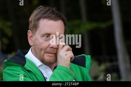 21. Oktober 2023, Sachsen, Königshain: Premierminister Michael Kretschmer in einer kurzen Pause während der Pflanzaktion „Oberlausitzer Zukunftswald“ in Königshain. Die Wiederaufforstung des 1,2 ha großen, geschädigten Gemeindegebiets ist das Ergebnis einer Crowgründungsaktion. Mit der Anpflanzung von über 3.000 Setzlingen verschiedener Baumarten durch Einwohner der Oberlausitz soll auf einem ehemaligen Rindenkäfer-beschädigten Gebiet ein klimaverträglicher, artenreicher Mischwald entstehen. Foto: Matthias Rietschel/dpa Stockfoto