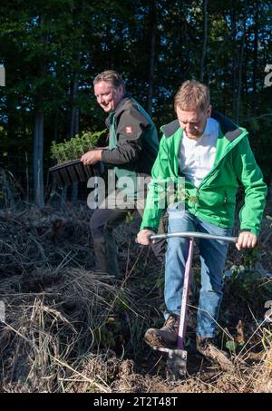 21. Oktober 2023, Sachsen, Königshain: Premierminister Michael Kretschmer (r) nimmt an der Pflanzkampagne „Oberlausitzer Zukunftswald“ in Königshain Teil. Die Wiederaufforstung des 1,2 ha großen, geschädigten Gemeindegebiets ist das Ergebnis einer Crowgründungsaktion. Mit der Anpflanzung von über 3.000 Setzlingen verschiedener Baumarten durch Einwohner der Oberlausitz soll auf einem ehemaligen Rindenkäferkäfer-geschädigten Gebiet ein klimaverträglicher, artenreicher Mischwald entstehen. Foto: Matthias Rietschel/dpa Stockfoto