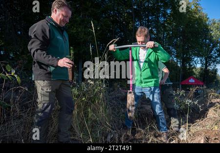 21. Oktober 2023, Sachsen, Königshain: Premierminister Michael Kretschmer (r) nimmt an der Pflanzkampagne „Oberlausitzer Zukunftswald“ in Königshain Teil. Die Wiederaufforstung des 1,2 ha großen, geschädigten Gemeindegebiets ist das Ergebnis einer Crowgründungsaktion. Mit der Anpflanzung von über 3.000 Setzlingen verschiedener Baumarten durch Einwohner der Oberlausitz soll auf einem ehemaligen Rindenkäferkäfer-geschädigten Gebiet ein klimaverträglicher, artenreicher Mischwald entstehen. Foto: Matthias Rietschel/dpa Stockfoto