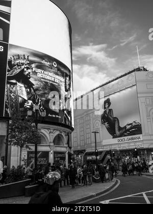 Schwarzweißwerbung und Menschenmassen im Piccadilly Circus, City of Westminster, London, England, Großbritannien, GB Stockfoto