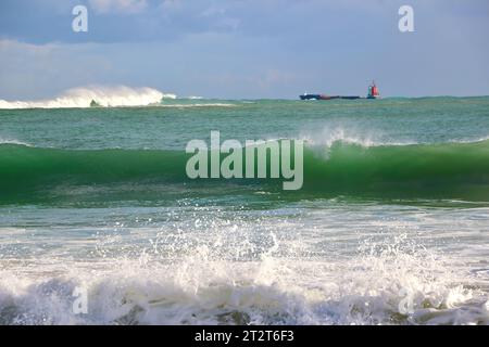 Ein Frachtschiff auf See, das die Bucht und den Hafen von Santander an einem sonnigen Oktobermorgen mit 10 Fuß Wellen verlässt Sardinero Santander Cantabria Spanien Stockfoto