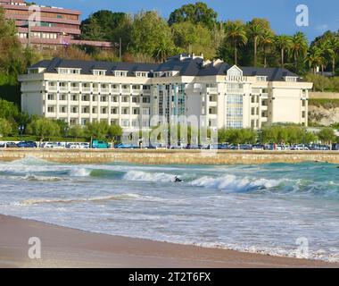 Das Hotel Chiqui mit Leuten, die an einem frischen windigen Herbstmorgen am Strand spazieren gehen Sardinero Santander Cantabria Spanien Stockfoto