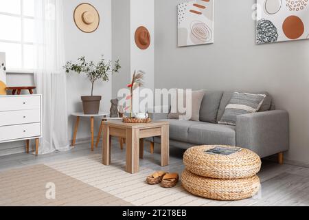 Wohnzimmereinrichtung mit Ikebana auf Tisch und Sofa Stockfoto