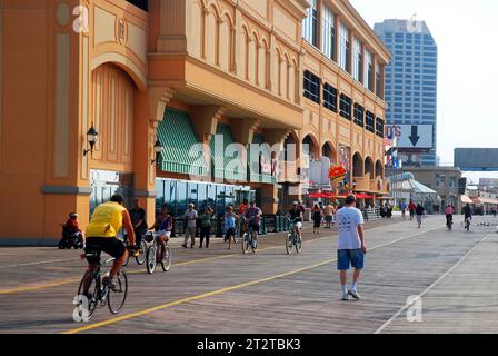 Eine kleine Menschenmenge spaziert und radelt entlang der Promenade von Atlantic City, New Jersey, an der Küste von Jersey vorbei an den großen Kasinos und Hotels Stockfoto