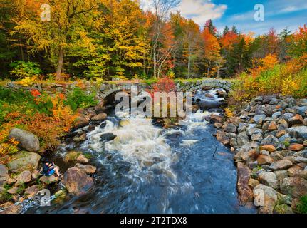 Stoddard, New Hampshire, USA. 14. Oktober 2021 Herbst in Neuengland. Rauschendes Wasser unter der doppelten Stone Arch Bridge und Herbstlaub am North Branch des Contoocook River an der Stadtgrenze Stoddard – Antrim im Hillsborough County New Hampshire. (Rick Friedman) Stockfoto