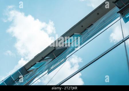 Atemberaubende Aufnahmen aus einem offenen Hochhausfenster, umrahmt von einem wunderschönen blauen Himmel und flauschigen weißen Wolken Stockfoto