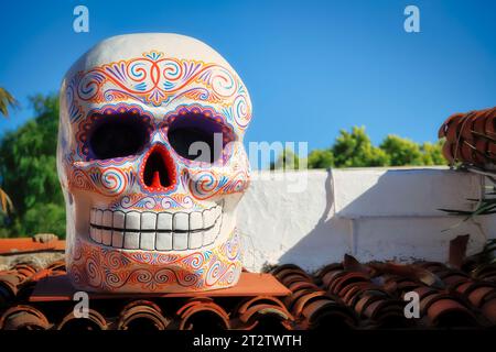 A Day of the Dead Skull sitzt auf einem Dach in der Sonne in der Altstadt von San Diego, Kalifornien. Stockfoto