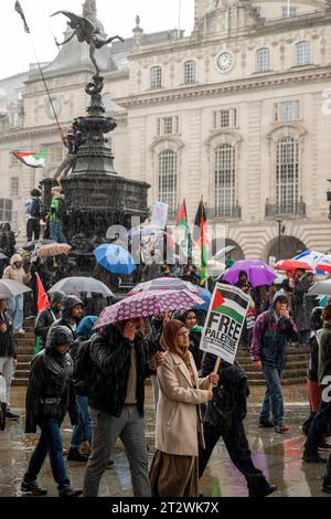 Demonstranten passieren Eros in London mit palästinensischen Fahnen und Plakat "Freies Palästina". Kundgebung gegen die Bombardierung von Gaza. London. Oktober 2023. Stockfoto