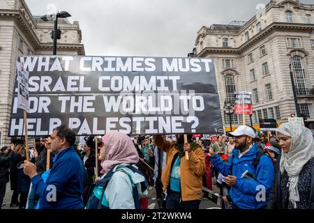 Protest gegen die Bombardierung des Gazastreifens mit einem großen Plakat: "Welches Verbrechen muss Israel begehen, damit die Welt Palästina hilft". London. Stockfoto