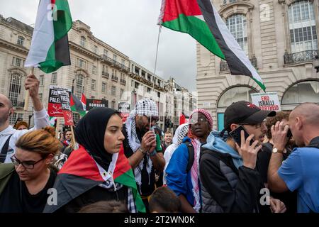 Junge Menschen auf einer Demonstration gegen die Bombardierung von Gaza mit Plaestinischen Flaggen und Plastinen. London Oktober 2023. Stockfoto