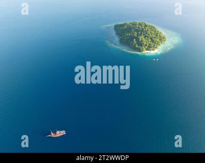 Eine idyllische, tropische Insel, umgeben von Korallenriffen, befindet sich in der Dampier Strait von Raja Ampat. Dieses abgelegene Gebiet weist eine hohe biologische Vielfalt der Meere auf. Stockfoto