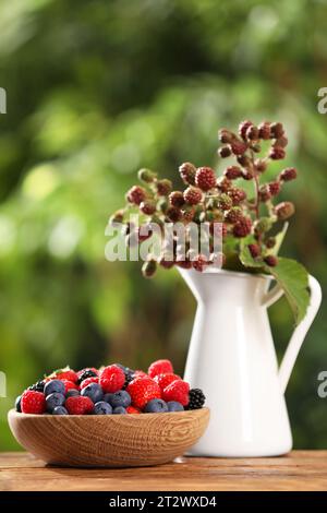 Verschiedene frische Beeren auf Holztisch draußen Stockfoto