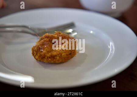 Frittierter Garnelenkuchen, Nahaufnahme von thailändischem Essen frittierter Garnelenkuchen auf weißem Teller auf einem Steintisch mit Pflaumensoße. Knuspriger, frittierter Garnelenkuchen. Stockfoto