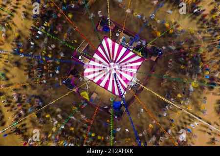 Baroda, Indien. Oktober 2023. (Bild mit einer Drohne) während des Navratri-Festivals tanzen die Menschen von oben den traditionellen Garba-Tanz im Kreis. Das hindu Navratri Festival, das 9 Nächte dauert, wird jedes Jahr im Oktober in ganz Nordindien, insbesondere im Bundesstaat Gujarat, gefeiert, um die Götter Durga zu ehren und den Sieg des Guten über das Böse zu feiern. Die Menschen versammeln sich auf offenem Gelände, um gemeinsam den traditionellen Garba-Tanz in traditionellen indischen Kurta- und Sari-Kleidern aufzuführen. (Foto: Davide Bonaldo/SIPA USA) Credit: SIPA USA/Alamy Live News Stockfoto